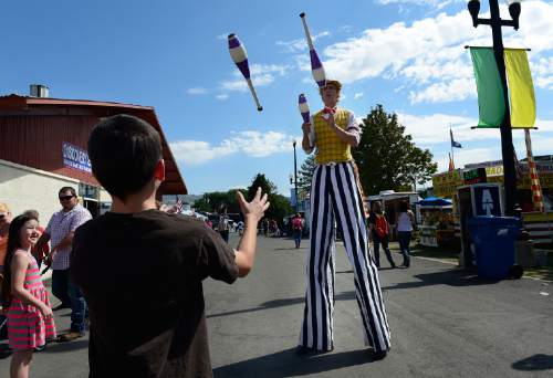 Scott Sommerdorf   |  The Salt Lake Tribune
"Leapin' Louie" juggles with a young fair visitor during the final day of the Utah State Fair, Sunday, September 14, 2014.