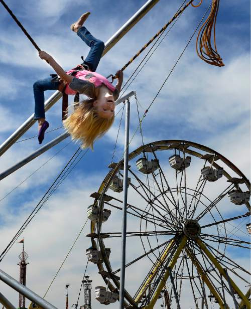 Scott Sommerdorf   |  The Salt Lake Tribune
Katie Park, 10, flips during her ride on the "Power Jump" during the final day of the Utah State Fair, Sunday, Sept. 14, 2014.