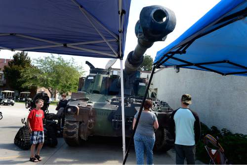 Scott Sommerdorf   |  The Salt Lake Tribune
Fair visitors examine a huge m109a6 "Paladin" self-propelled howitzer at the National Guard booth during the final day of the Utah State Fair, Sunday, Sept. 14, 2014.