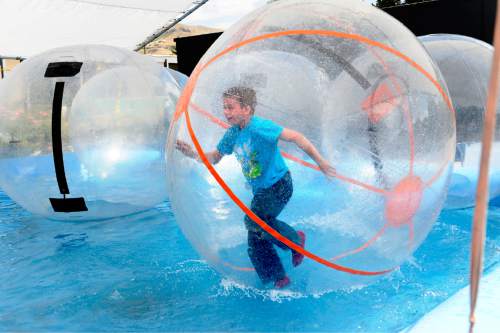 Scott Sommerdorf   |  The Salt Lake Tribune
Nine-year-old Gavin McReynolds runs inside an inflatable ball in the "Walk on Water" game during the final day of the Utah State Fair, Sunday, Sept. 14, 2014.