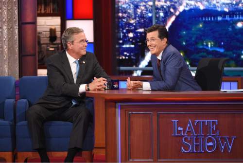 Stephen Colbert, right, talks with Republican presidential candidate Jeb Bush during the premiere episode of "The Late Show," Tuesday Sept. 8, 2015, in New York. Bush and actor George Clooney were the guests for Colbert's debut. (Jeffrey R. Staab/CBS via AP)