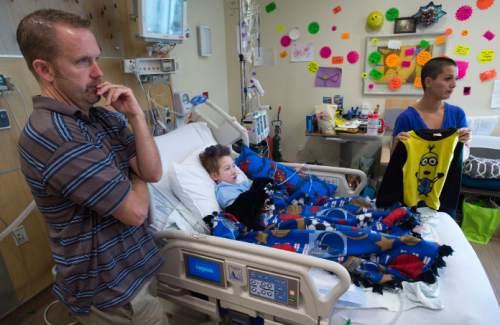 Steve Griffin  |  The Salt Lake Tribune

Chris and Hollie Warner with their son Teagan, 9, in the Burn Trauma Intensive Care Unit at University Hospital in Salt Lake City, Friday, September 11, 2015.  Teagan suffered burns over 30 percent of his body when the fleece he was wearing (Hollie is holding the tops of the fleece pajamas) caught fire during a camp out this summer.