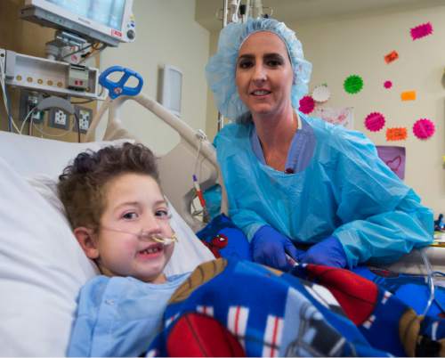 Steve Griffin  |  The Salt Lake Tribune

Teagan Warner, 9, with his nurse Natalie Murphy in the Burn Trauma Intensive Care Unit at University Hospital in Salt Lake City, Friday, September 11, 2015.  Teagan suffered burns over 30 percent of his body when the fleece he was wearing caught fire during a camp out this summer.