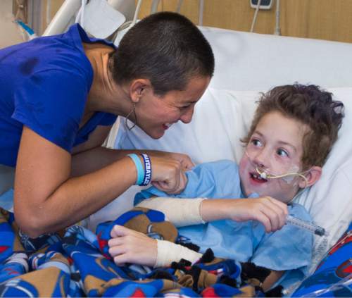 Steve Griffin  |  The Salt Lake Tribune

Hollie Warner laughs with her son Teagan, 9, after he squirted her with a syringe filled with water in the Burn Trauma Intensive Care Unit at University Hospital in Salt Lake City, Friday, September 11, 2015.  Teagan suffered burns over 30 percent of his body when the fleece he was wearing caught fire during a camp out this summer.