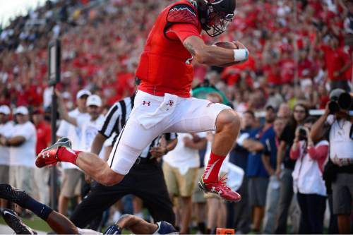 Scott Sommerdorf   |  The Salt Lake Tribune
Utah QB Travis Wilson leaps as he scores on a 12 yard run to give Utah a quick 7-0 lead. Utah and Utah State were tied 14-14 at the half at Rice-Eccles, Friday, September 11, 2015.