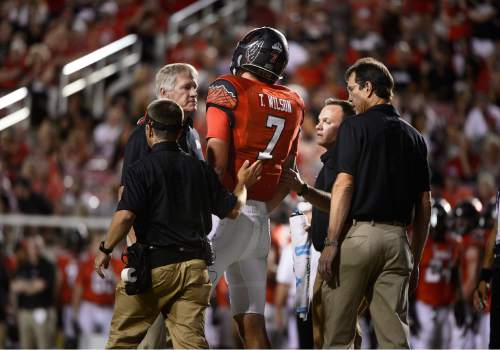 Scott Sommerdorf   |  The Salt Lake Tribune
Utah QB Travis Wilson is accompanied to the sideline by medical staff after he ran the ball 3 yards to the USU 4 during first half play. Utah and Utah State were tied 14-14 at the half at Rice-Eccles, Friday, September 11, 2015.
