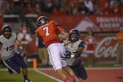 Leah Hogsten  |  The Salt Lake Tribune
Utah Utes quarterback Travis Wilson (7) is pinched with pressure from Utah State Aggies safety Devin Centers (37). University of Utah is tied with Utah State 14-14 at halftime at Rice-Eccles Stadium, Friday, September 11, 2015.