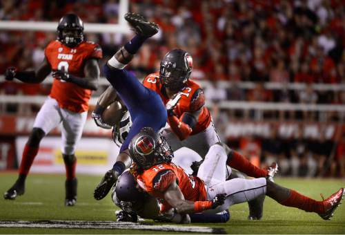 Scott Sommerdorf   |  The Salt Lake Tribune
Utah LB Gionni Paul (13), and Utah DB Justin Thomas (12), upend Utah State Aggies running back LaJuan Hunt (21). Utah and Utah State were tied 14-14 at the half at Rice-Eccles, Friday, September 11, 2015.