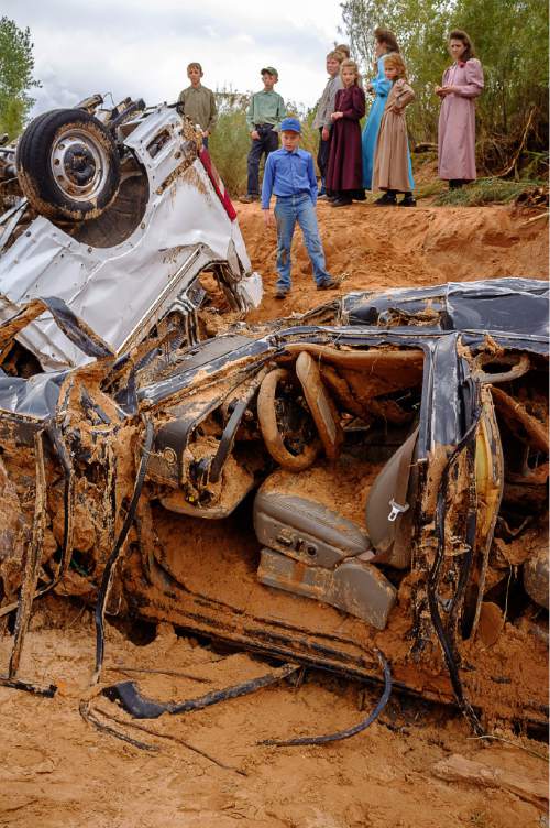 Trent Nelson  |  The Salt Lake Tribune
People take in the scene in a Hildale wash where two vehicles came to rest after a flash flood that killed nine people (with four still missing) Tuesday September 15, 2015., the day after an SUV and a van were washed off a road during a flash flood in this polygamous Utah-Arizona border community.