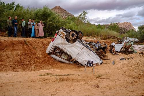 Trent Nelson  |  The Salt Lake Tribune
People take in the scene in a Hildale wash where two vehicles came to rest after a flash flood that killed nine people (with four still missing) Tuesday September 15, 2015., the day after an SUV and a van were washed off a road during a flash flood in this polygamous Utah-Arizona border community.