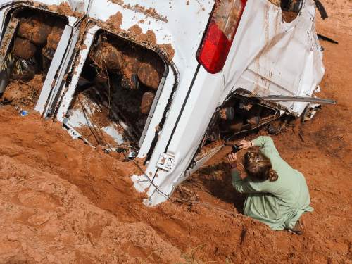 Trent Nelson  |  The Salt Lake Tribune
A young girl photographs the remains of a van at the spot in a Hildale wash where a flash flood killed nine people (with four still missing) Tuesday September 15, 2015., the day after an SUV and a van were washed off a road during a flash flood in this polygamous Utah-Arizona border community.