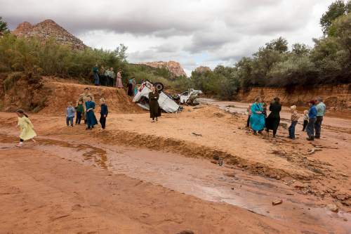 Trent Nelson  |  The Salt Lake Tribune
People at the spot in a Hildale wash Tuesday September 15, 2015 where two vehicles ended up after being washed away in a flash flood. Nine people died (with four still missing) when the SUV and van were washed off a road during a flash flood in this polygamous Utah-Arizona border community.