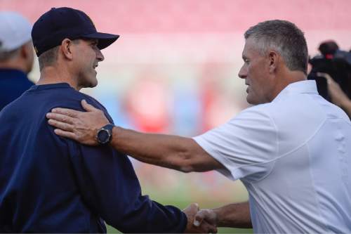 Michigan coach Jim Harbaugh shakes hands with Utah coach Kyle Whittingham before the start of their NCAA college football game Salt Lake City on Thursday, Sept. 3, 2015. (Francisco Kjolseth/The Salt Lake Tribune via AP) DESERET NEWS OUT LOCAL TV OUT MAGS OUT