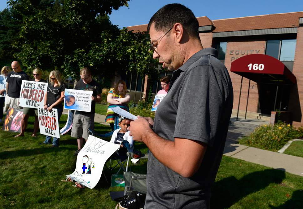 Scott Sommerdorf   |  The Salt Lake Tribune
Pro-life protestor Robert Woods reads a prayer as he and about 20 others stood outside the Salt Lake City Planned Parenthood as part of a nationwide protes ton Saturday. Organizers say a coalition of 60 groups planned to protest at more than 300 Planned Parenthood facilities in the nation.
