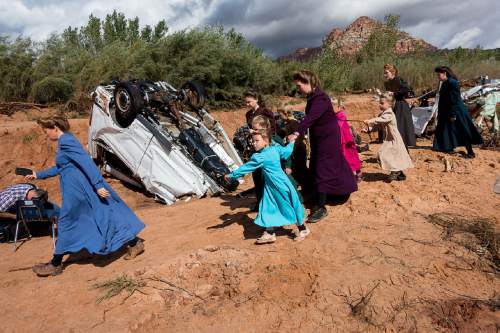 Trent Nelson  |  The Salt Lake Tribune
A group of FLDS women quickly leave the scene of a flash flood incident as a TV cameraman begins filming, Wednesday September 16, 2015.