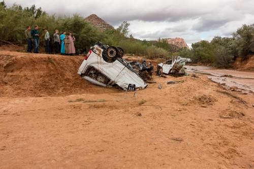 Trent Nelson  |  The Salt Lake Tribune
People at the spot in a Hildale wash Tuesday September 15, 2015 where two vehicles ended up after being washed away in a flash flood. Nine people died (with four still missing) when the SUV and van were washed off a road during a flash flood in this polygamous Utah-Arizona border community.