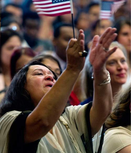 Steve Griffin  |  The Salt Lake Tribune

New United States of America citizen Blanca Zapata cries and waves the American Flag as she sings along to the song "Proud to be an American" during a citizenship ceremony hosted by the U.S. Citizenship and Immigration Services at This Is The Place Heritage Park in Salt Lake City, Thursday, September 17, 2015. Zapata was joined by 139 other immigrants who become new citizens of the United States of America after taking the Oath of Allegiance.
