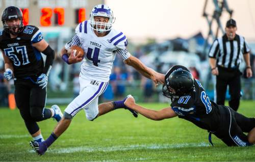 Chris Detrick  |  The Salt Lake Tribune
Tooele's Ryan Brady (4) runs past Stansbury's Clayton Stanworth (57) and Stansbury's Mason Smith (67) during the game at Stansbury High School Friday September 11, 2015.
