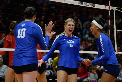 Francisco Kjolseth | The Salt Lake Tribune
BYU's Cosy Burnett, center, celebrates a point with teammates as they battle Utah in the annual meeting between the schools' women's volleyball teams at Utah.