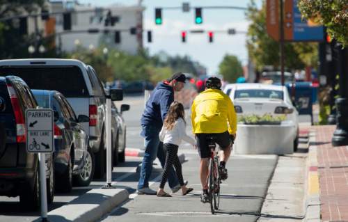 Steve Griffin  |  The Salt Lake Tribune
A bike rider yields to pedestrians in the new bike lanes on 300 South near State Street in Salt Lake City on Friday.