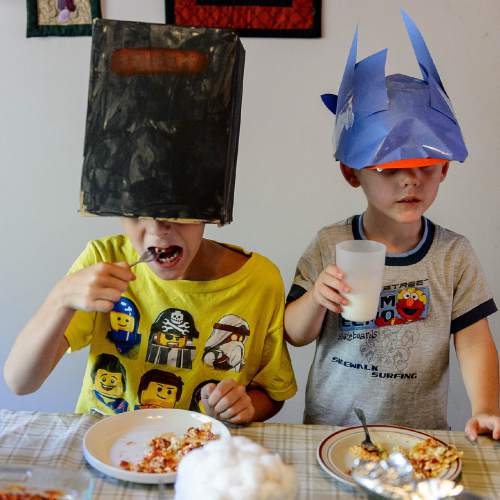 Trent Nelson  |  The Salt Lake Tribune
Matthew and Mark Benson wear masks at the dinner table. Two of the family of eight are part of the Utah Children's Project, a research study that picks up where the National Children's Study left off. That ambitious national study ended last year, abruptly, but the University of Utah researchers did not want the project to end. The idea is to follow children from birth until age 18 to try to learn more about childhood illnesses and diseases and to learn more about the role of genetics and environment in children's health. They were photographed at the family's home in Logan, Wednesday September 2, 2015.