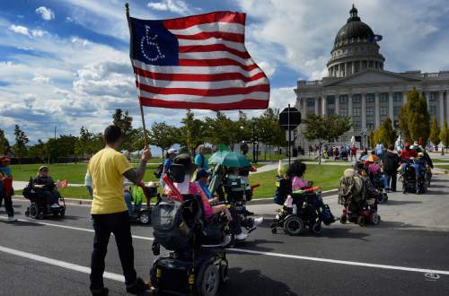 Scott Sommerdorf   |  The Salt Lake Tribune
Nearly 200 members of ADAPT, the national grassroots advocacy group for disability rights, marched to the Utah Capitol. Utahns with disabilities spoke about their struggles to achieve the freedom to choose where they can live independently, Sunday, September 26, 2015.