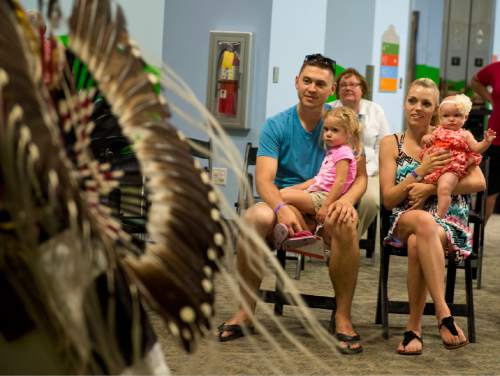 Lennie Mahler  |  The Salt Lake Tribune

Bray and Shaelee Phillips hold their daughters, Aleeya and Haylee, as they watch Nino Reyes perform Native American dances in the World's Fair at the Discovery Gateway Children's Museum on Friday, Sept. 25, 2015.