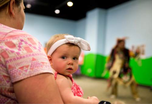 Lennie Mahler  |  The Salt Lake Tribune

Ali Heiner holds her daughter, Hannah, as they watch Nino Reyes perform Native American dances in the World's Fair at the Discovery Gateway Children's Museum on Friday, Sept. 25, 2015.