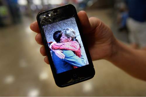 Scott Sommerdorf   |  The Salt Lake Tribune
While waiting for her son Tyler to return home from his mission in Peru, Sheri Randolph shows a photo of her hugging her son as he left on the mission two years prior. At the Salt Lake International Airport, Wednesday, September 9, 2015.