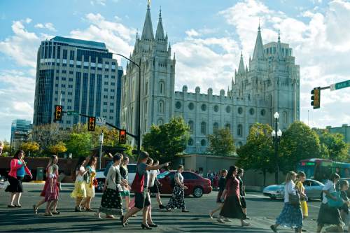 Lennie Mahler  |  The Salt Lake Tribune
Women pass by the LDS Temple on their way to the first session of the 185th LDS General Conference on Saturday, in Salt Lake City. The session is for all LDS women and girls eight years or older.