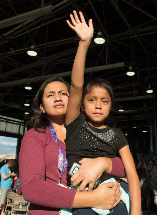 Rick Egan  |  The Salt Lake Tribune

Mary Jane Ungor holds her sister Sabrina, as they wave goodbye to their sister, Fofoaivaoese Ungor, as she boarded the plane with soldiers of the116th Engineer Company (Horizontal), Utah National Guard, board the plane at Roland Wright Air Base, as they leave for two months of training before their deployment to Kuwait, Sunday, October 4, 2015.