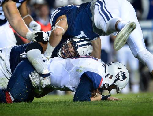 Scott Sommerdorf   |  The Salt Lake Tribune
BYU defensive lineman Bronson Kaufusi (90) grimaces as he brings Connecticut quarterback Bryant Shirreffs (4) down during first half play. UCONN and BYU were tied 7-7 at the half, October 2, 2015.