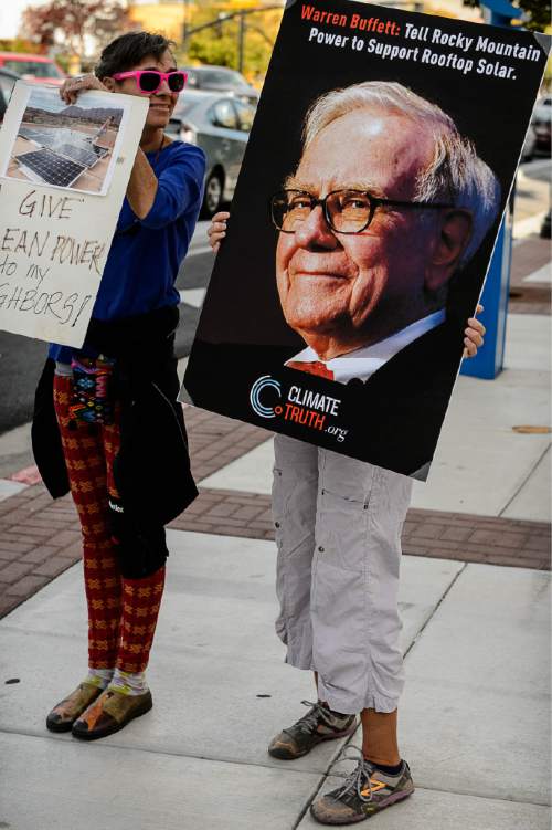 Trent Nelson  |  The Salt Lake Tribune
Women hold signs as clean energy advocates gather outside the Utah Public Service Commission (PSC) in Salt Lake City, Thursday October 8, 2015, before a hearing on fees levied by utilities on rooftop solar users.
