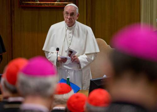 Pope Francis holds a prayer book as he opens a morning session of the two-week long Synod of bishops, at the Vatican, Tuesday, Oct. 6, 2015. (AP Photo/Alessandra Tarantino)