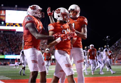 Utah running back Devontae Booker, center, celebrates with teammates after scoring a touchdown against California during the first half of an NCAA college football game Saturday, Oct. 10, 2015, in Salt Lake City. (Scott Sommerdorf/The Salt Lake Tribune via AP) DESERET NEWS OUT; LOCAL TELEVISION OUT; MAGS OUT; MANDATORY CREDIT