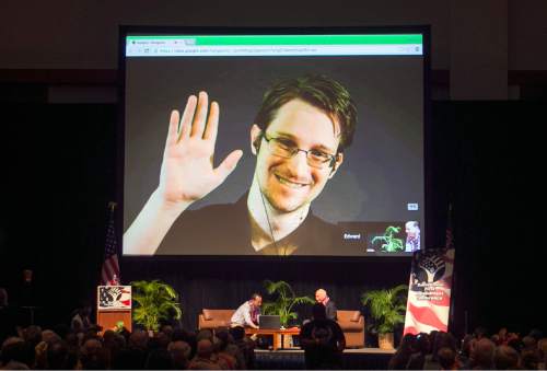 FILE - In this Feb. 14, 2015 file photo, Edward Snowden appears on a live video feed broadcast from Moscow at an event sponsored by ACLU Hawaii in Honolulu. The former National Security Agency worker, who leaked classified documents about government surveillance, started tweeting Tuesday, Sept. 29, 2015. (AP Photo/Marco Garcia, File)