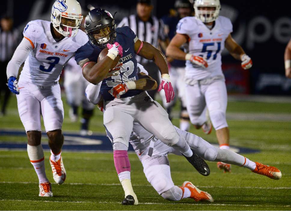Scott Sommerdorf   |  The Salt Lake Tribune
Utah State Aggies RB Devante Mays (32) drags Bronco tacklers at the end of a long run during second half play. Utah State defeated Boise State 52-26 in Logan, Friday, October 15, 2015.