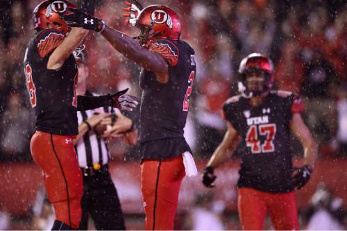 Scott Sommerdorf   |  The Salt Lake Tribune
Utah Utes WR Kenneth Scott (2) celebrates with Utah Utes WR Britain Covey (18), left, after he gathered in an 11 yard catch in the rain to score for Utah during first half play. The TD gave Utah a 14-10 lead. Utah led Arizona State 14-10 at the half, Saturday, October 17, 2015.