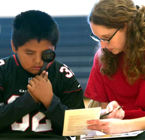 Rick Egan  |  The Salt Lake Tribune

Lisa Crandall gives an eye exam to Paul Begay, 9, at Navajo Mountain High School, Saturday, September 26, 2015.