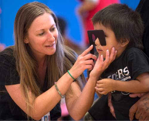 Rick Egan  |  The Salt Lake Tribune

Volunteer  technician, Evelyn Rusche gives Trestan Warren, an eye test, at Navajo Mountain High School, Saturday, September 26, 2015.