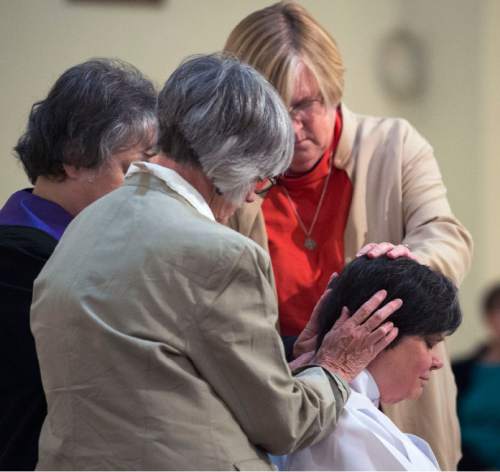 Steve Griffin  |  The Salt Lake Tribune

Friends, supporters and family members lay their hands on Clare Julian Carbone at the First United Methodist Church in Salt Lake City during her ordination to the priesthood by a group called Association of Roman Catholic Women Priests  Sunday, October 18, 2015.  The Catholic Church does not recognize such ordinations, but the women priest movement  has ordained 220 women since beginning in Germany in 2002.