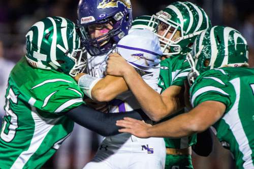 Chris Detrick  |  The Salt Lake Tribune
North Summit's Braxten Northrup (15) is tackled by South Summit's Parter Fitzgerald (45) South Summit's Skyler McCormick (58) and South Summit's Broughton Flygare (71) during the game at South Summit High School Thursday October 15, 2015.