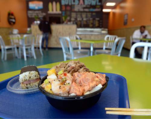 Al Hartmann  |  The Salt Lake Tribune
Poke bowl of Sweet Chili Shrimp with mango, Spicy Ahi Tuna, and Kalua Pig at the Laid Back Poke Shack at 6213 E. Highland Drive in Holladay. Left,  is "Musubi," a seaweed-wrapped rice roll with Spam.