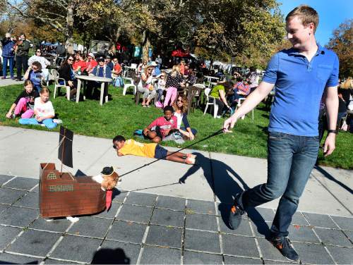 Scott Sommerdorf   |  The Salt Lake Tribune
Chris Peterson steers "Snarls" the dog dressed as a pirate ship during the at the "Howl-o-Ween" Pet Costume Contest  where Snarls won the "most creative" award at the at the last Farmers Market in Pioneer Park, Saturday, October 24, 2015.