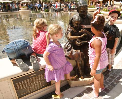 Leah Hogsten  |  The Salt Lake Tribune
The multimillion-dollar, 5,000-square-foot fountain features six fine-art bronze statues, created by sculptor Brian Keith that were dedicated Friday, June 15, 2012 in Farmington. Children play on one of the scuptures titled "Imagine." The Station Park shopping center in Farmington unveiled a world-class show fountain with choreographed lights, music, color and 30-60-foot high dancing water.