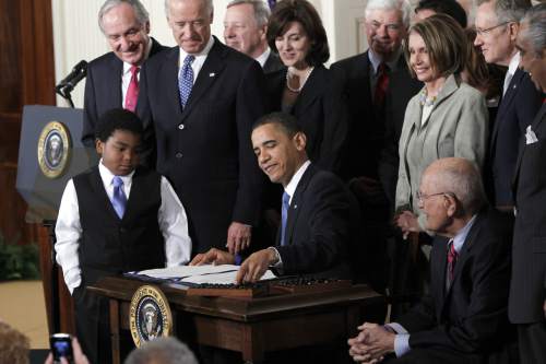 FILE - In this March 23, 2010, file photo, President Barack Obama reaches for a pen to sign the health care bill in the East Room of the White House in Washington. Nonprofit co-ops, the health care law's public-spirited alternative to mega insurers, are awash in red ink and many have fallen short of sign-up goals, a government audit has found. (AP Photo/Charles Dharapak, File)