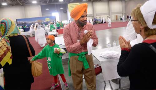 Al Hartmann  |  The Salt Lake Tribune
Tarlochan Gill of Salt Lake City greets the several thousand attending the Parliament of the World's Religions "Langar" at the Salt Palace Convention Center Friday, Oct. 16.  Dozens of members of the Sikh religion served the conference attendees sitting together on the floor in the 500-year-old Sikh religion tradition where vegetarian food is served to all for free, regardless of religion or class.  Langar expresses the ideals of community, sharing and oneness of mankind.