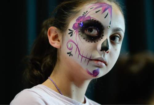 Francisco Kjolseth | The Salt Lake Tribune
Morgan Torrez, 11, joins others getting their face painted for the 12th annual Day of the Dead at the Utah Cultural Celebration Center in West Valley City on Sunday, Nov. 1, 2015. Una Mano Amiga constructed a central altar, surrounded by many community altars and Dia de Los Muertos-themed vignettes, creating a colorful, creative, and informative exhibition. Authentic Mexican food, music, dance, ceremonies, games, vendors, activities and art stations were also part of the celebration.