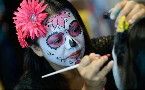 Francisco Kjolseth | The Salt Lake Tribune
Veronica Roman of Isabella's Face Painting applies the finishing touches to a young face for the 12th annual Day of the Dead at the Utah Cultural Celebration Center in West Valley City on Sunday, Nov. 1, 2015. Una Mano Amiga constructed a central altar, surrounded by many community altars and Dia de Los Muertos themed vignettes, creating a colorful, creative and informative exhibition. Authentic Mexican food, music, dance, ceremonies, games, vendors, activities and art stations were also part of the celebration.