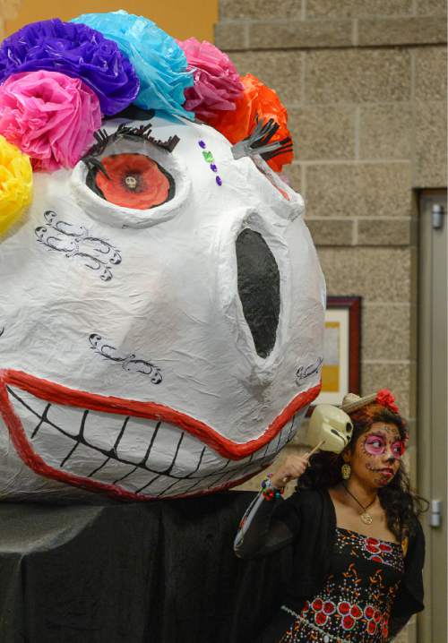 Francisco Kjolseth | The Salt Lake Tribune
Estephany Castanon Pasillas, 17, poses for a photograph in front of a large paper mache skull as people gather for the 12th annual Day of the Dead at the Utah Cultural Celebration Center in West Valley City on Sunday, Nov. 1, 2015. Una Mano Amiga constructed a central altar, surrounded by many community altars and Dia de Los Muertos-themed vignettes, creating a colorful, creative and informative exhibition. Authentic Mexican food, music, dance, ceremonies, games, vendors, activities and art stations were also part of the celebration.